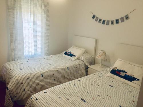 een slaapkamer met twee bedden en een raam bij MET&GOLF OLIVA NOVA BEACH in Oliva