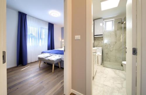 a bedroom with a bed and a bathroom with a shower at Villa Lungomare in Malinska