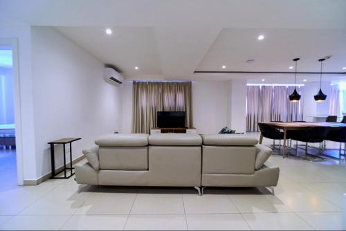 a living room with a couch and a dining room at Suncity Hotel Apartment in Accra