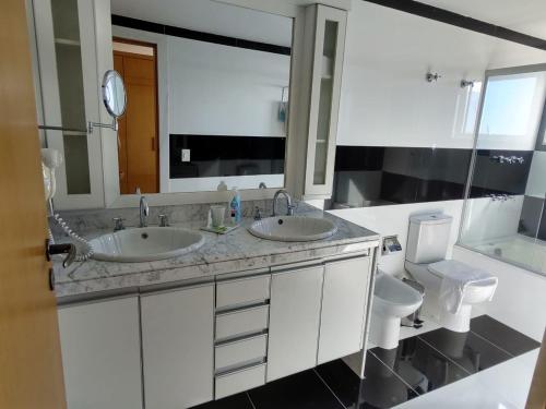 uma casa de banho com 2 lavatórios e um WC em Royal Urban Macaé Hotel em Macaé