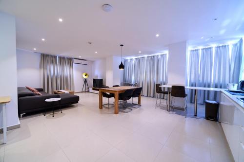a living room with a black couch and a table at Suncity Hotel Apartment in Accra