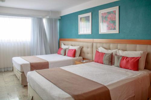 Postel nebo postele na pokoji v ubytování Royal Urban Macaé Hotel