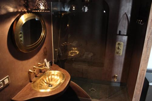 uma casa de banho com um lavatório dourado e um chuveiro em Hotel la Boheme em Cáceres