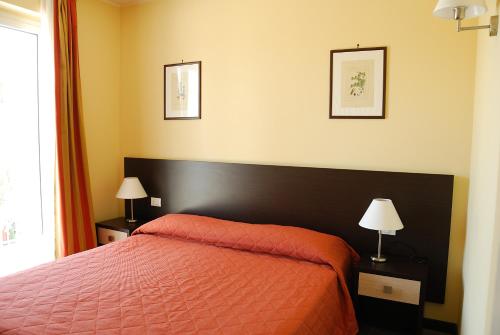 - une chambre avec un lit rouge et deux lampes dans l'établissement Appartamento IL POGGIO, à Tortoreto Alto