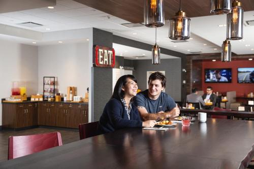 Ein Mann und eine Frau sitzen an einem Tisch in einem Restaurant in der Unterkunft Holiday Inn Edmonton South - Evario Events, an IHG Hotel in Edmonton