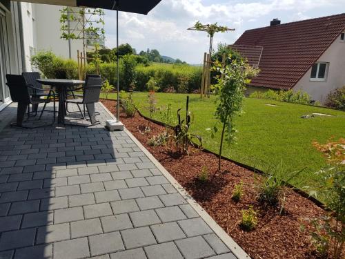 a patio with a table and chairs in a garden at Ferienwohnung Daudi in Bad Dürrheim