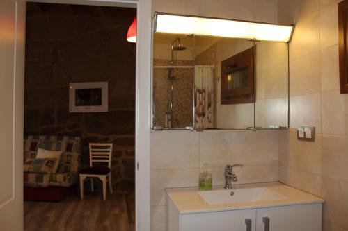 y baño con lavabo y espejo. en Apartamento Rural "Os Telesforos", en Allariz
