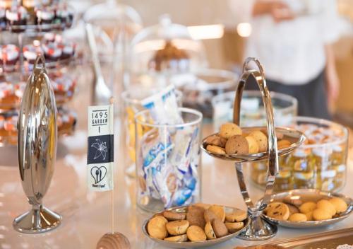 a table topped with plates of cookies and bowls of food at Boiardo Hotel in Scandiano