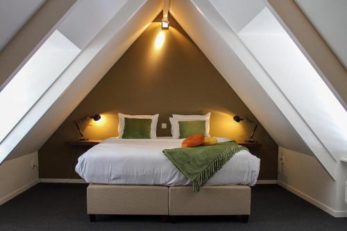 a bedroom with a bed in an attic at Casa Vinke op Ameland in Hollum
