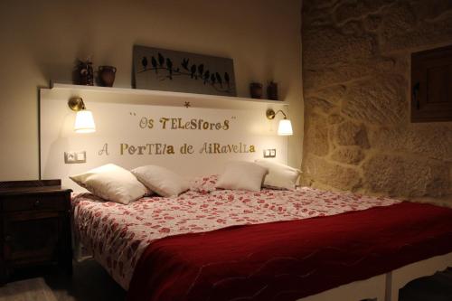 a bedroom with a bed with a red comforter at Apartamento Rural "Os Telesforos" in Allariz