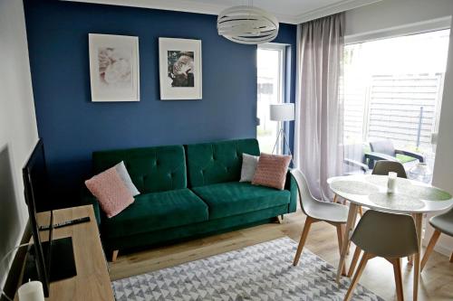 sala de estar con sofá verde y mesa en Chill&Sun Green, en Łukęcin