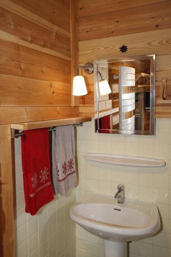 a bathroom with a sink and a mirror and towels at Le Martagon in Vars