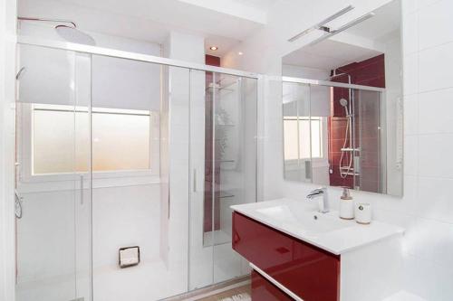 a bathroom with a sink and a glass shower at Deslumbrante Apartamento en Plaza España, by Batuecas in Madrid
