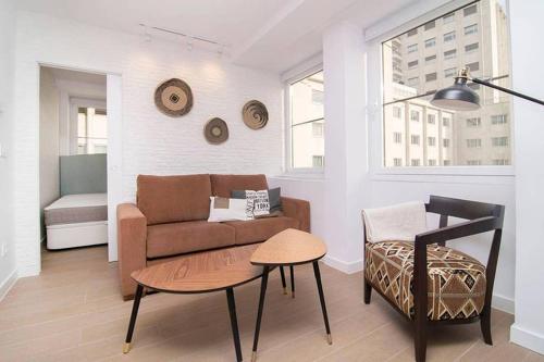 ein Wohnzimmer mit einer Couch und einem Tisch in der Unterkunft Deslumbrante Apartamento en Plaza España, by Batuecas in Madrid