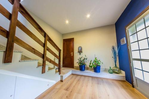 ein Wohnzimmer mit Treppen und Topfpflanzen in der Unterkunft Casamary Buhardilla in Pontevedra
