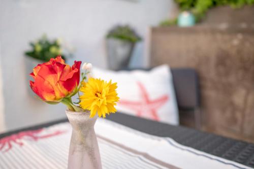 een vaas met twee bloemen op een tafel bij FeWo Kleine Insel in Bad Segeberg