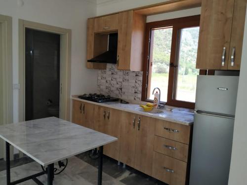 a kitchen with wooden cabinets and a white refrigerator at EVALiN in Mugla