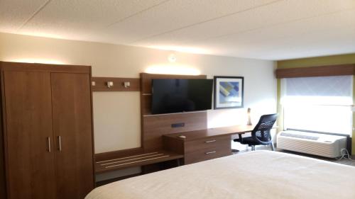 a hotel room with a bed and a desk with a television at Holiday Inn Express Edgewood-Aberdeen-Bel Air in Edgewood