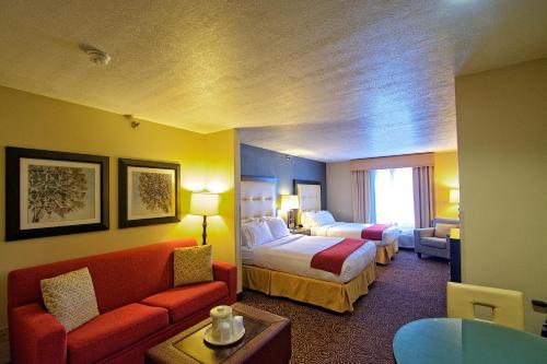 a hotel room with two beds and a couch at Holiday Inn Express Ogden, an IHG Hotel in Ogden