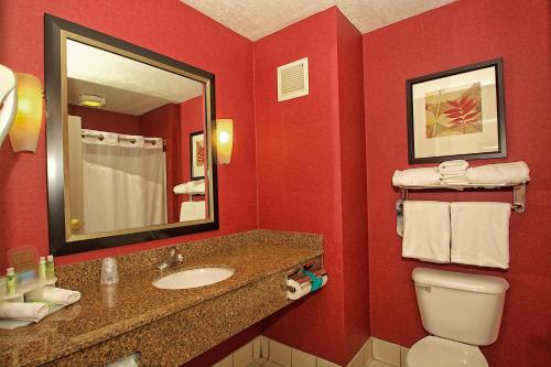 Baño rojo con lavabo y aseo en Holiday Inn Express Ogden, an IHG Hotel en Ogden