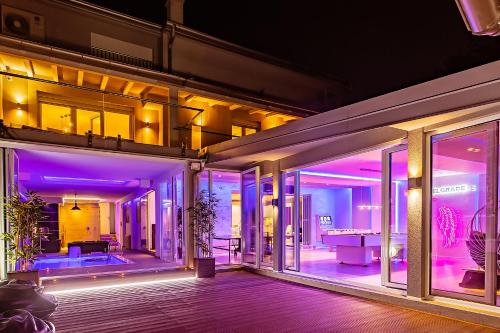 an open house with purple lights on a house at #1 Luxury Villa with Pool, Gameroom, Spa, Zen Yard in Belgrade