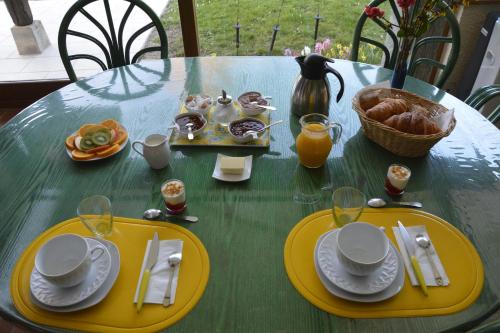una mesa verde con platos amarillos de comida. en Les Rendzines en Nuisement-sur-Coole