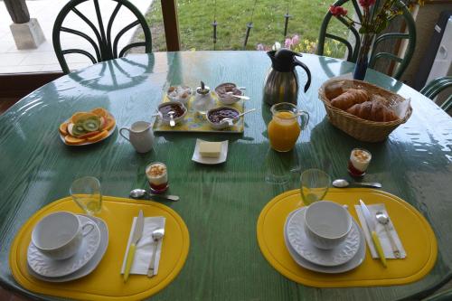 a green table with yellow plates of food on it at Les Rendzines in Nuisement-sur-Coole