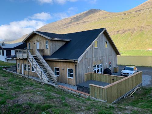 a large wooden house with a black roof at Lokk-Inn Apartments in Norðdepil