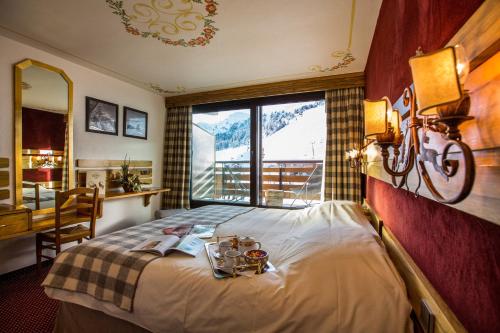een hotelkamer met een bed en een raam bij Hôtel Alpen Ruitor in Méribel