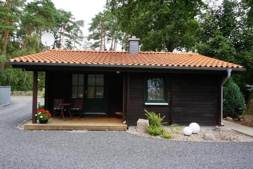 a small house with a roof on a driveway at Ferienhaus Schneeberger in Winsen Aller