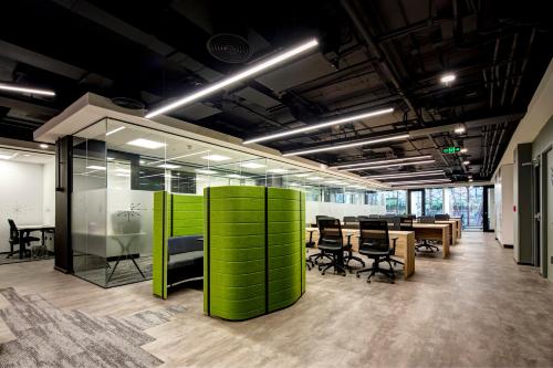 an office with a green wall and tables and chairs at Hotel Nodo - El hotel que respira in Santiago