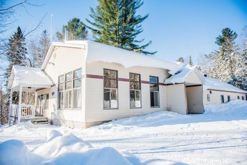 a house with snow on the ground in front of it at Chalets Lanaudière in Rawdon