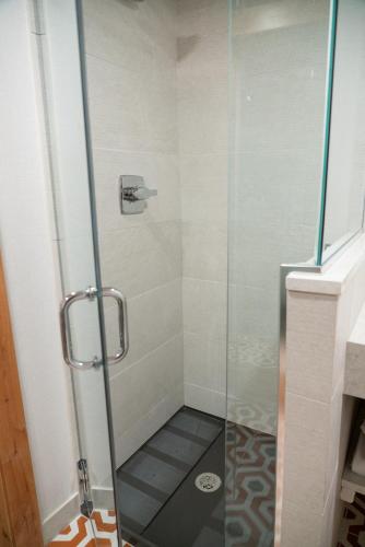 a shower with a glass door in a bathroom at The Dorothy Motel in Banff