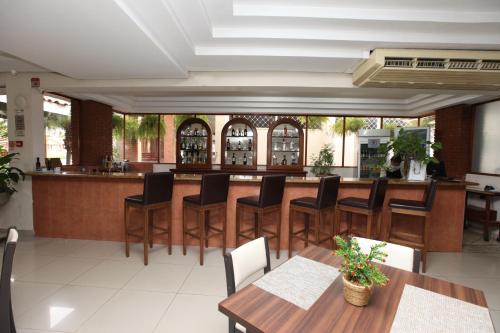 a restaurant with a bar with wooden tables and chairs at IPÊ PARK Convention Hotel in Sao Jose do Rio Preto