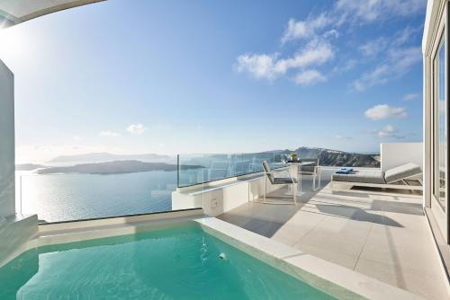 a house with a swimming pool and a view of the water at Alti Santorini Suites - Caldera View in Megalochori