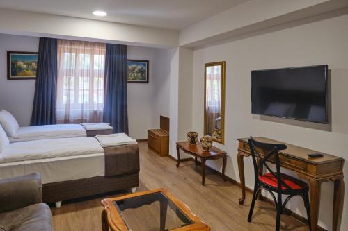 a hotel room with a bed and a flat screen tv at Hotel Splendid in Pleven