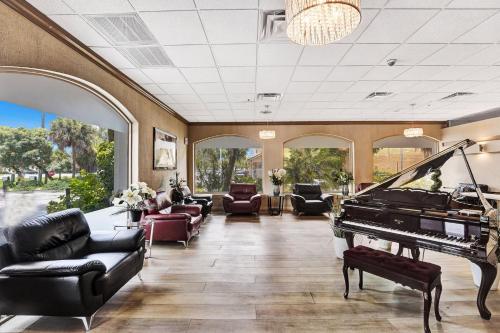 a living room with a piano and couches at Plaza Hotel Fort Lauderdale in Fort Lauderdale
