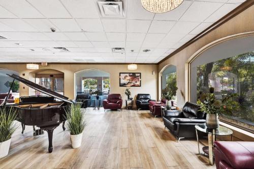 a living room with a piano and furniture at Plaza Hotel Fort Lauderdale in Fort Lauderdale