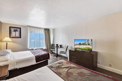 a hotel room with two beds and a flat screen tv at Plaza Hotel Fort Lauderdale in Fort Lauderdale