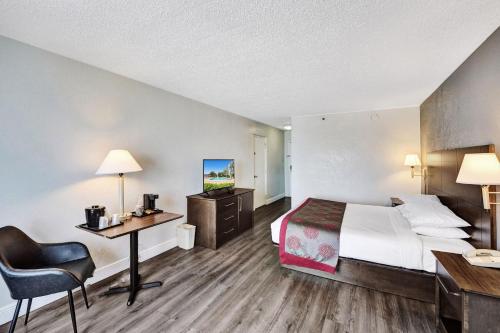 a hotel room with a bed and a desk at Plaza Hotel Fort Lauderdale in Fort Lauderdale