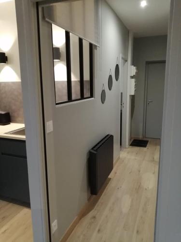 a hallway of a kitchen with a sink and a mirror at Charmant Appartement Muret Centre in Muret
