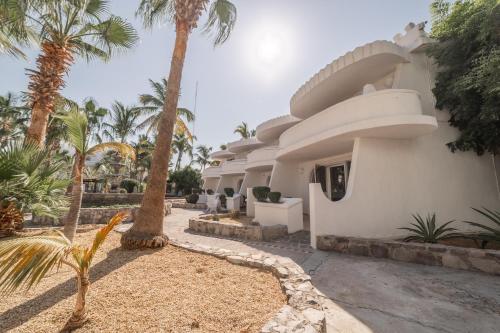 a house with palm trees in front of it at Hotel & Suites El Moro in La Paz
