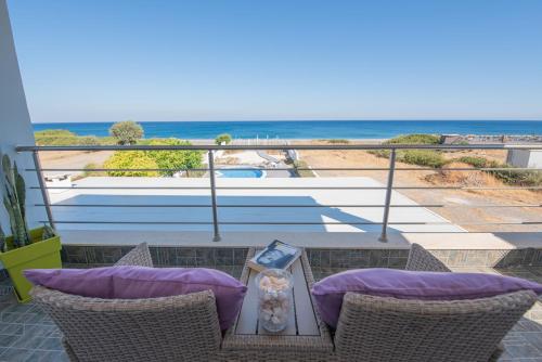 a balcony with a table and chairs with a view of the beach at Aegiali Sea View Villa in Gennadi