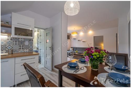 a kitchen and dining room with a table with a vase of flowers at Apartament MARCEL Centrum in Szklarska Poręba