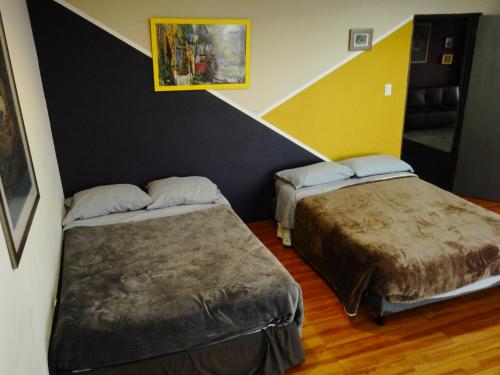 a room with two beds and a painting on the wall at Caravansaro Penthouse Polanco in Mexico City
