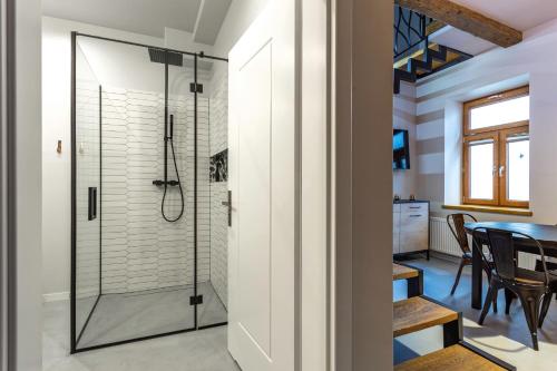a bathroom with a shower and a dining room at Aparthotel Zakątna B&B in Tarnów