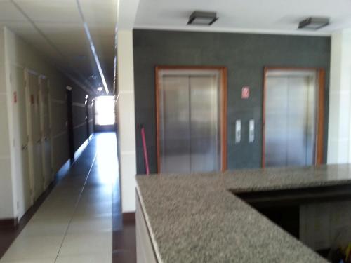 a hallway in a building with a counter and a hallway with doors at Apart las Rastras talca in Talca