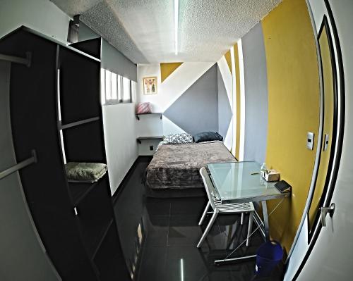 a small room with a bed and a glass table at Caravansaro Penthouse Polanco in Mexico City