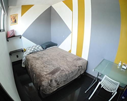 a small bedroom with a bed and a table at Caravansaro Penthouse Polanco in Mexico City