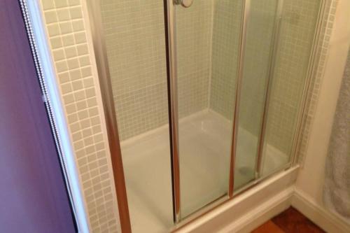 a shower with a glass door in a bathroom at 3 Bedroom 2 Bathrooms Apartment in Central Penzance in Penzance